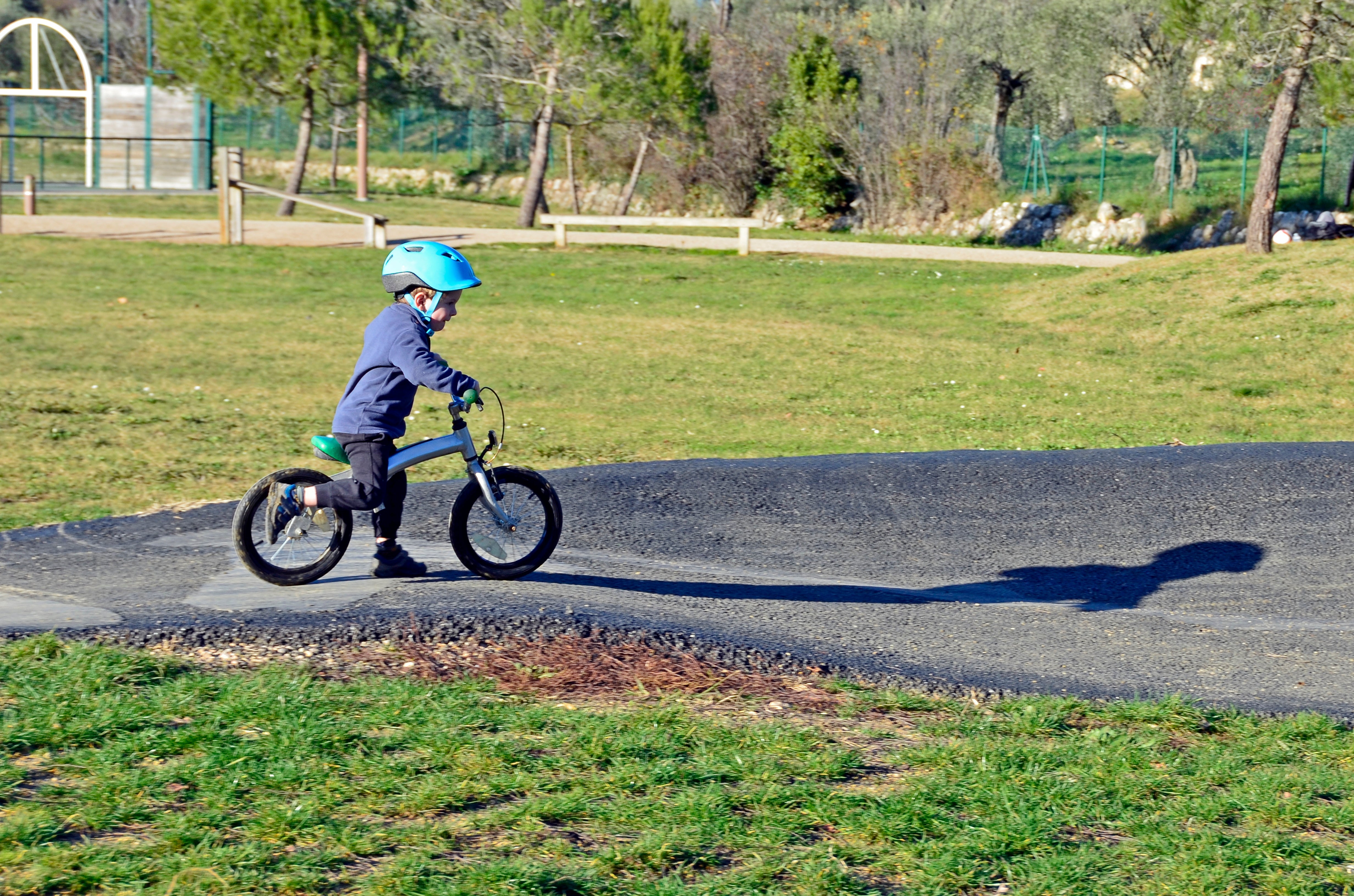 enfant avec casque bleu sur une draisienne