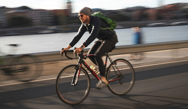 Un cycliste roule vers son travail avec le bon équipement pour le vélotaf. 