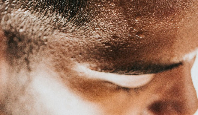 Les gouttes de transpiration perlent sur le front du cycliste après un trajet en vélotaf. 