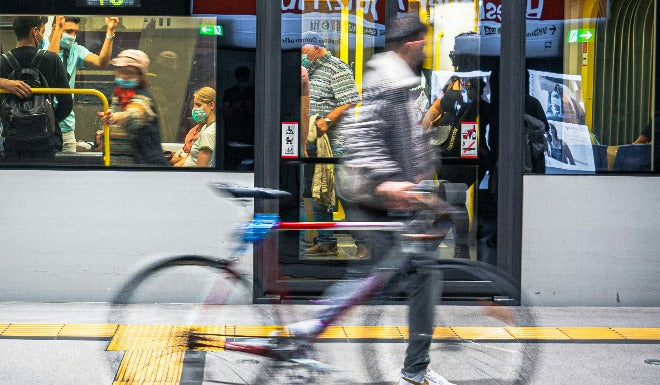 un homme marche sur les quais du metro en poussant son velo
