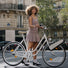 Femme posant avec velo equipe du moteur electrique portable Clip Bike Explorer 192 Wh de la marque 125 en milieu urbain