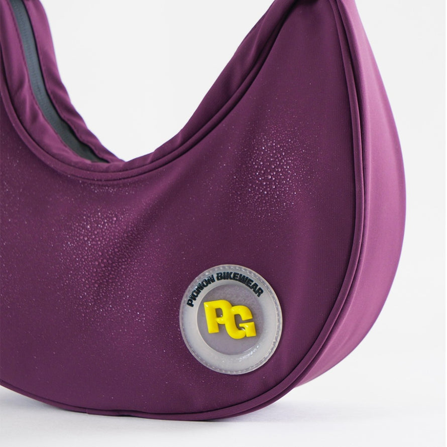 Sac a main velo imperméable Aravis Pignon 1,8L violet avec logo PG en gros plan et gouttes d'eau
