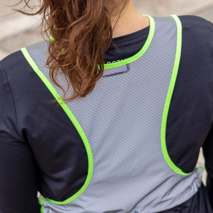 vue arrière du gilet réfléchissant gofluo pace gris porté par une cycliste urbaine