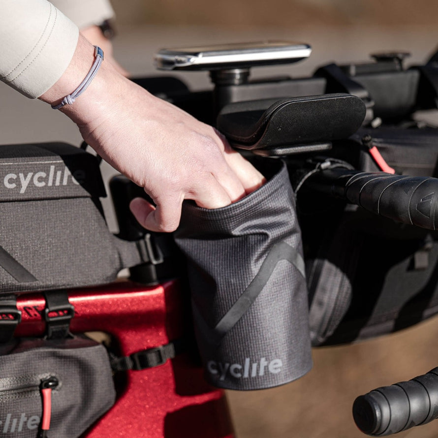Sacoche de potence velo 77 Cyclite Foud pouch 02 noire avec main en train de ranger un objet