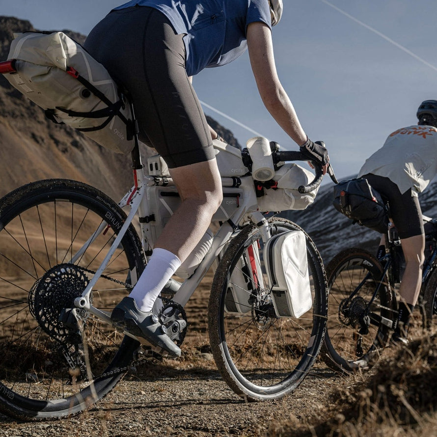 Cycliste avec sacoche de potence velo 77 Cyclite Foud pouch 02 en terrain accidenté pour bikepacking