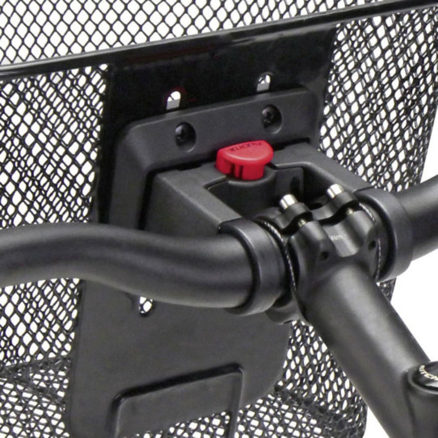 Zoom sur le système de fixation rapide KLICKfix installé sur le guidon d’un vélo avec panier avant métallique.