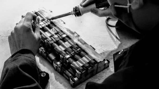 Persona che ripara la batteria di una bici elettrica