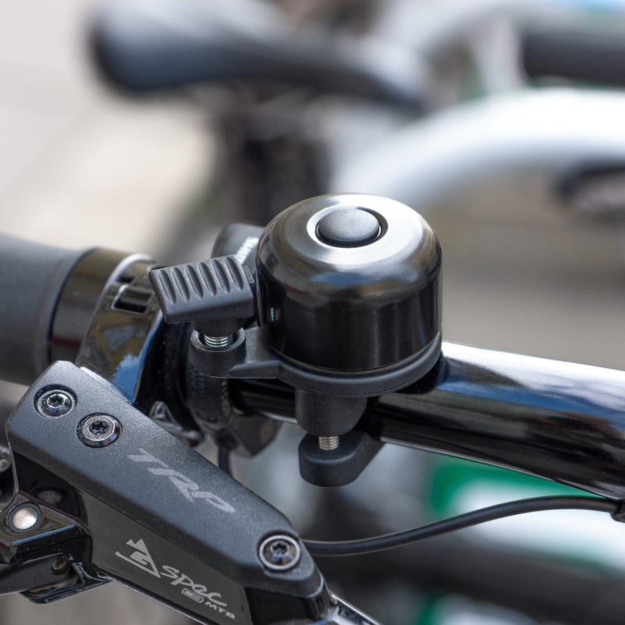 Sonnette AirBell Pro 22 mm noire installée sur guidon de vélo, design robuste et son clair