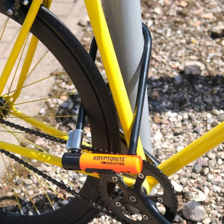 Antivol U Kryptonite Evolution LS fixé sur vélo jaune pour une sécurité optimale