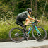 Cycliste avec sacoche de selle bikepacking Apidura Racing noire et jaune sur vélo de route en pleine sortie