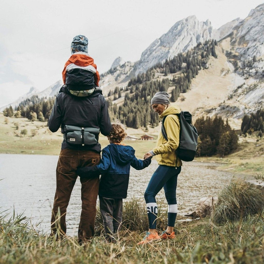 Famille en randonnée avec la banane MeroMero Piha portée à la taille dans un environnement montagneux.