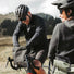 Cycliste gravel accédant au contenu de sa sacoche MeroMero Piha lors d’une pause en pleine nature.