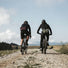 Deux cyclistes gravel roulant avec une banane MeroMero Piha fixée à la taille