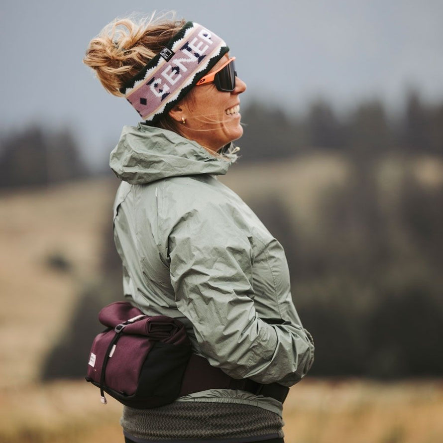 Randonneuse portant la banane MeroMero Piha lors d’une pause en extérieur.