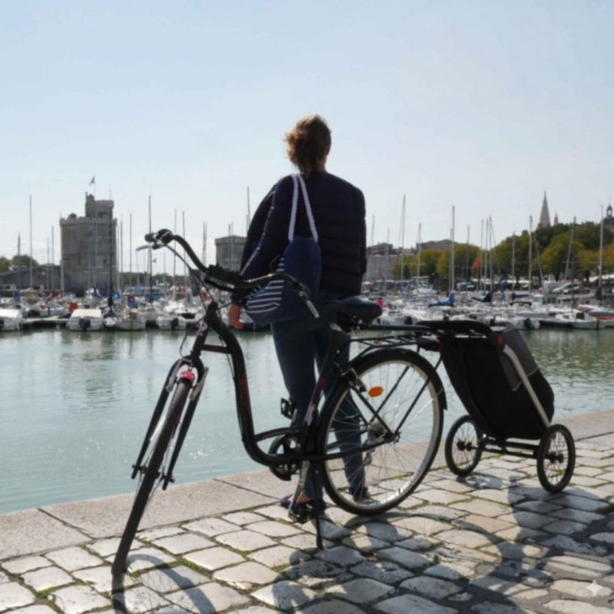 Remorque vélo chariot Shopping Trailer 50L de bike_original attachée à vélo au bord de l'eau en milieu urbain