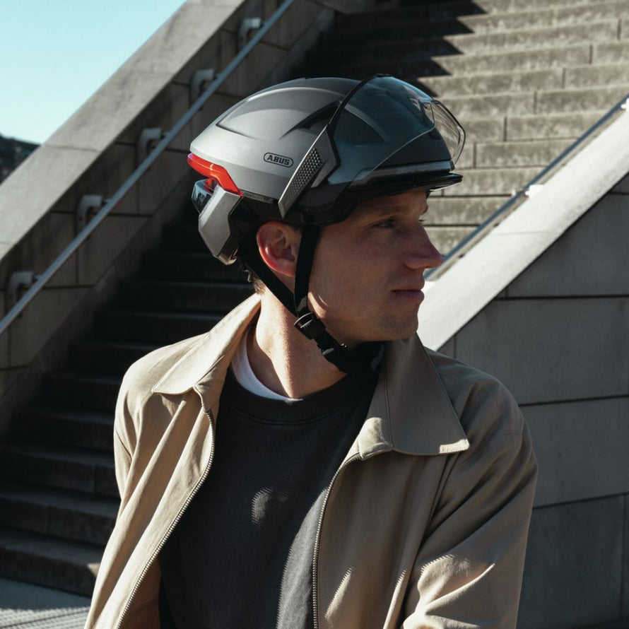 Casque vélo connecté Abus Hyp-E avec télécommande, clignotants et visière protectrice.