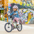 Enfant roulant à vélo avec le casque PUKY rose rétro, protection sûre et design moderne