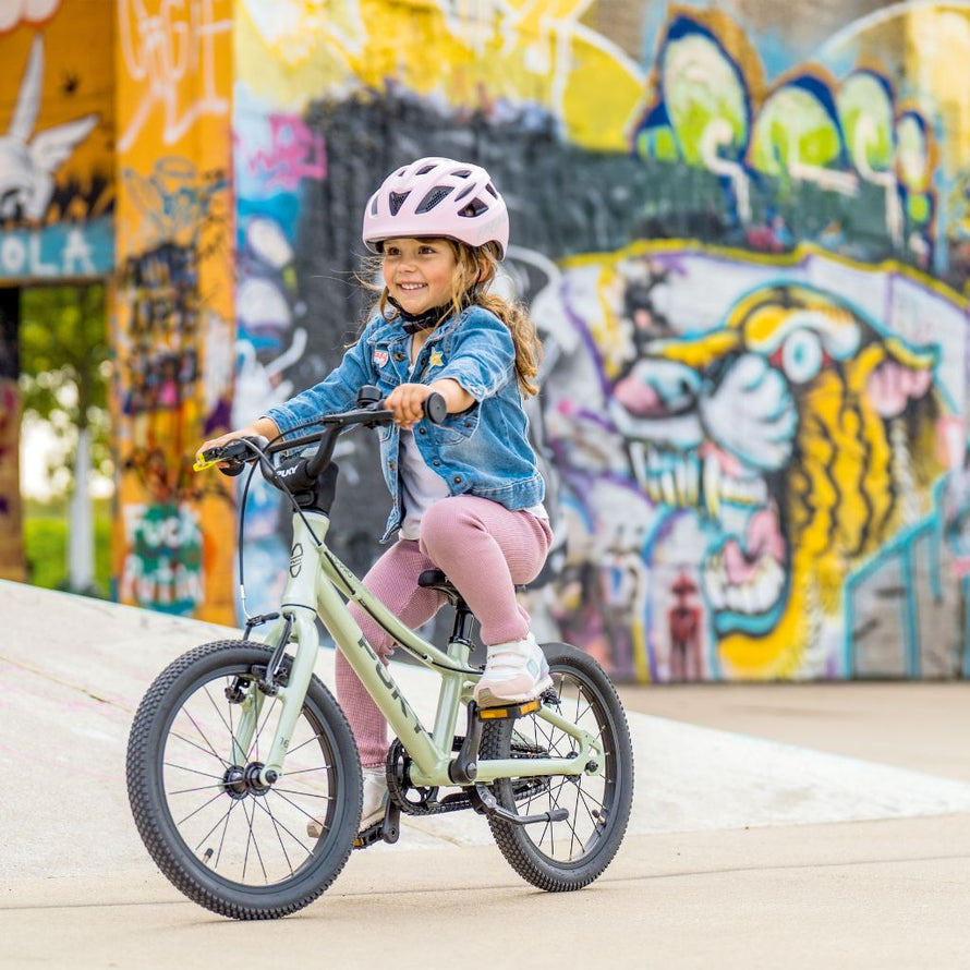 Enfant roulant à vélo avec le casque PUKY rose rétro, protection sûre et design moderne