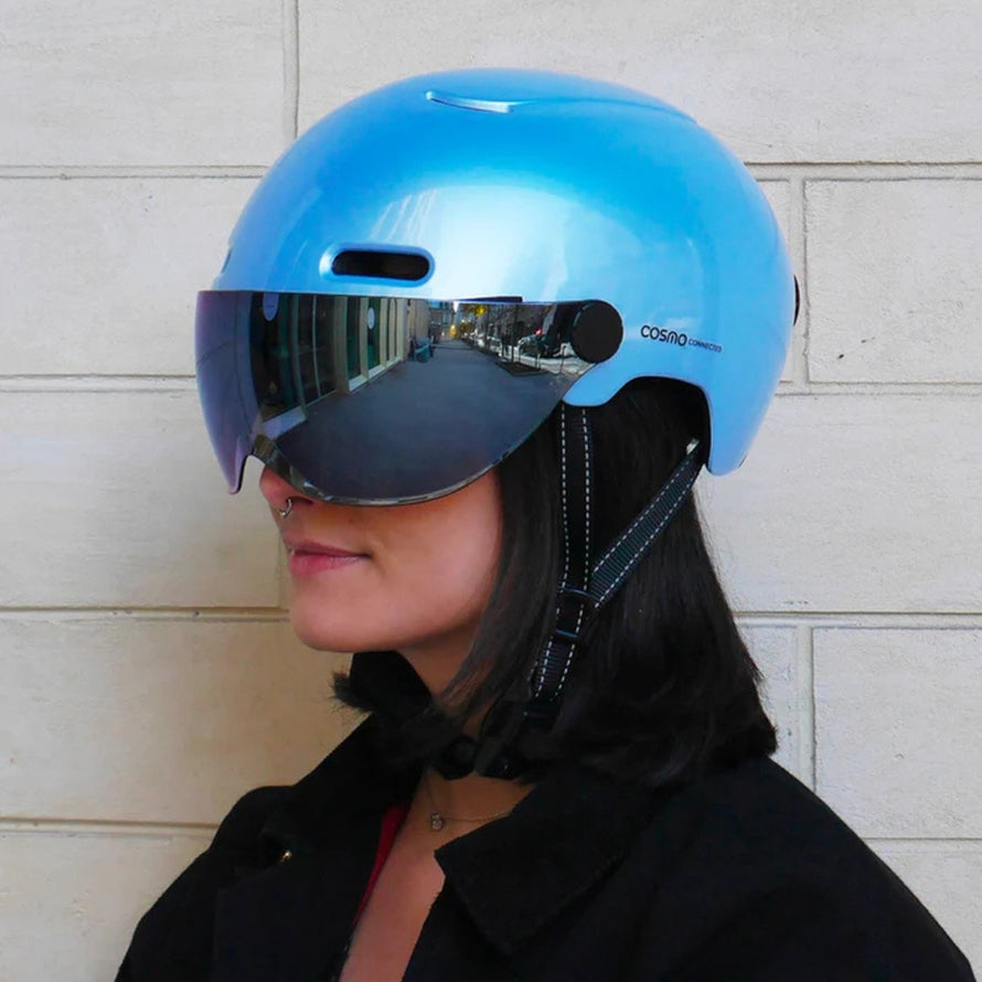 Casque vélo connecté Cosmo Connected Fusion bleu porté par une femme en milieu urbain avec visière intégrée