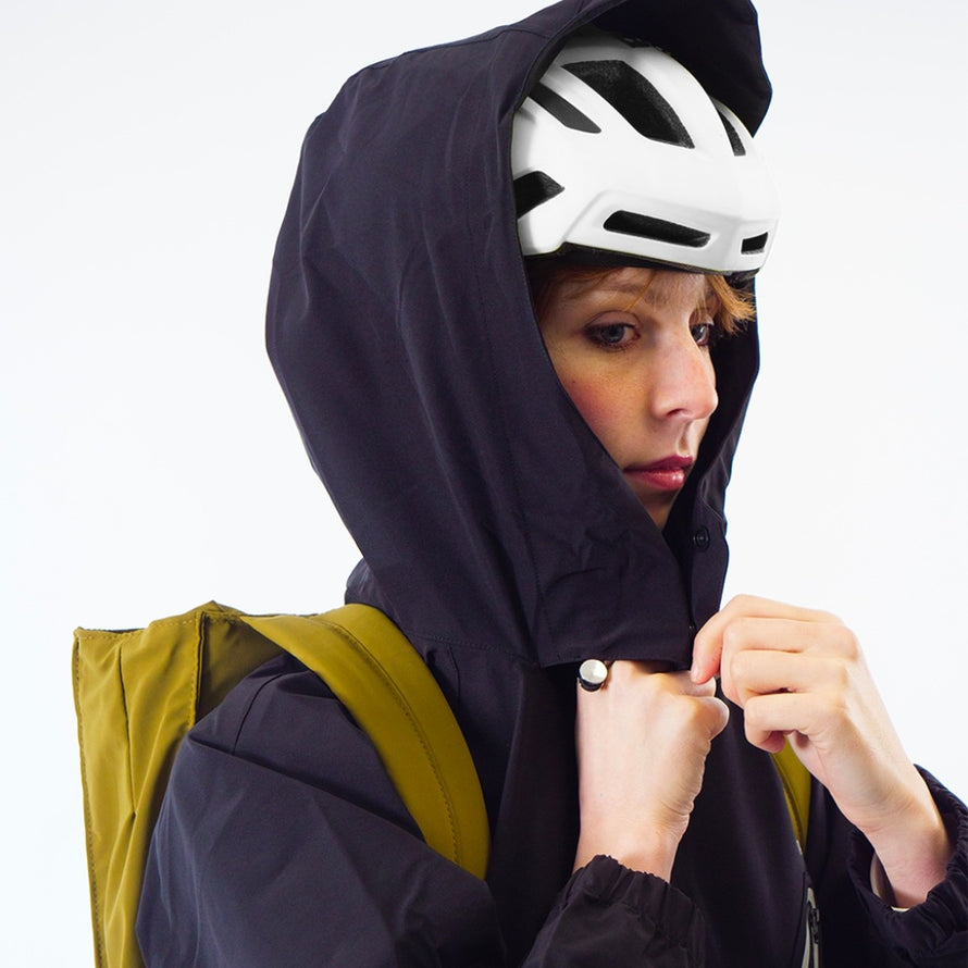 Femme portant la combinaison imperméable vélo ENTEGA Pignon Clothing unisexe avec capuche ajustée et fermeture zippée