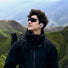 Jeune cycliste portant les ecouteurs velo Shokz OpenFit Air 2 en pleine nature montagneuse