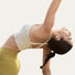 Femme en posture de yoga avec ecouteurs bluetooth velo Shokz Opendots 2 pour un son clair et sans fil