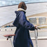 Trench-coat imperméable unisexe Fudoon bleu marine porté en ville avec trottinette, style urbain et protection pluie