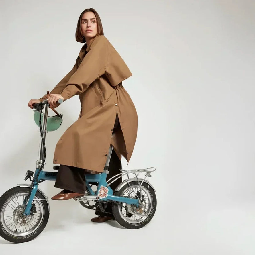 Trench-coat imperméable unisexe Fudoon marron porté avec vélo pliable, style urbain et protection pluie ajustable