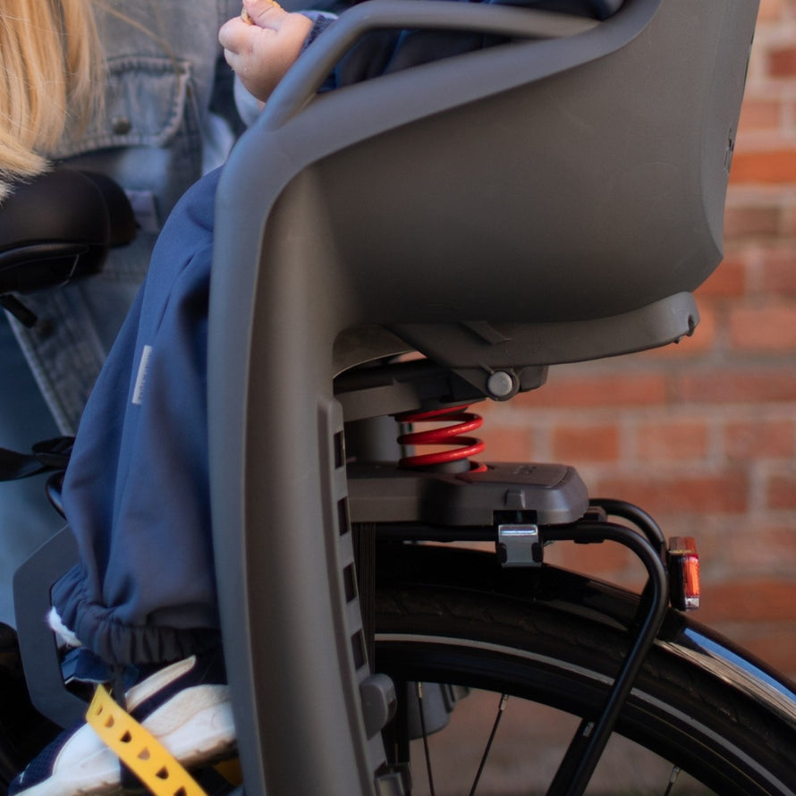 Siège vélo enfant Hamax Amiga avec suspension rouge pour porte-bagages, confort et sécurité renforcés