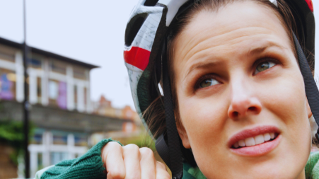 cycliste qui ajuste la jugulaire de son casque