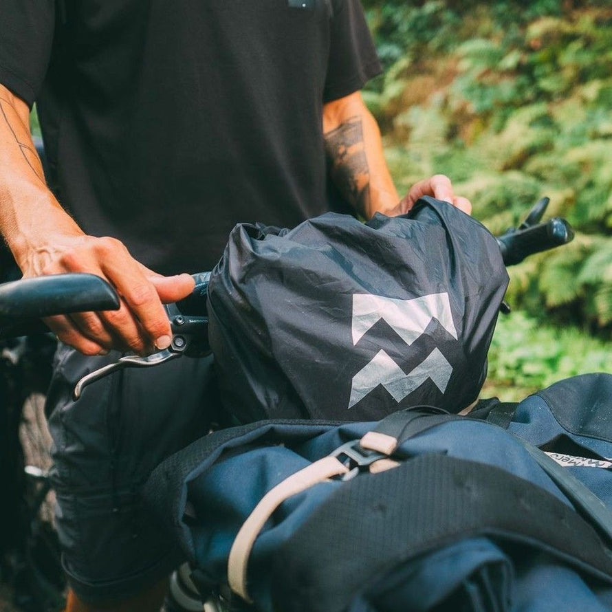 Housse pluie MeroMero pour sacoche vélo, protégeant le matériel des intempéries.