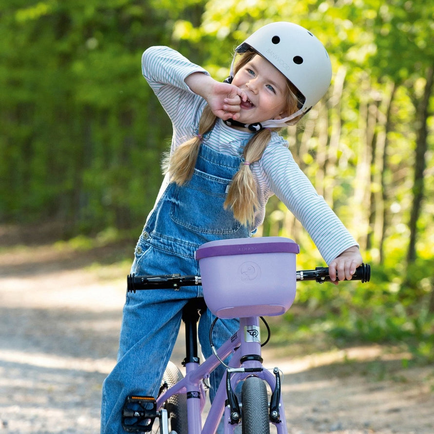 Panier vélo enfant Klickfix Lori Basket 2L lilas fixé sur guidon de vélo enfant avec casque blanc