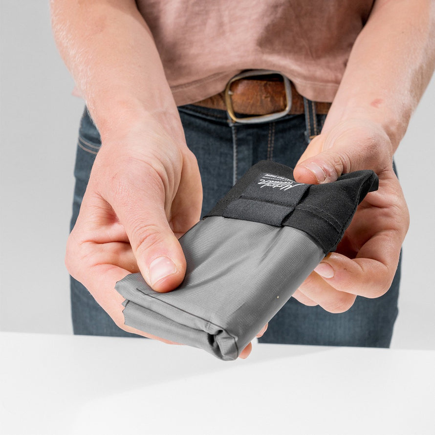 Homme pliant la couverture compacte Matador Pocket Blanket, modèle pratique et léger pour activités outdoor