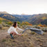 Femme dépliant la mini couverture Matador Pocket Blanket Mini en pleine nature pour activités vélo outdoor