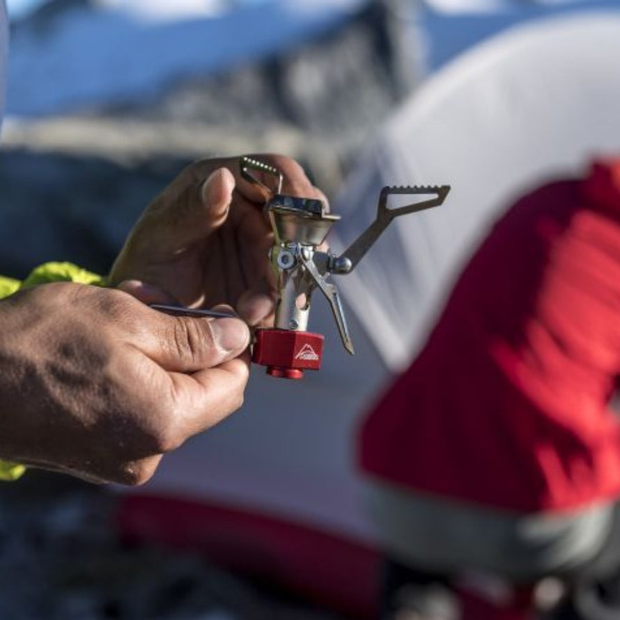 Réchaud ultraléger MSR Pocketrocket 2 dans une main sur un camp