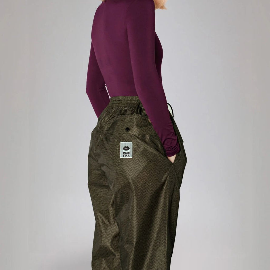 Détail du pantalon Rainkiss Herringbone, motif élégant à chevrons et logo Rainkiss à l’arrière, alliance parfaite entre mode et fonctionnalité pour les jours de pluie.