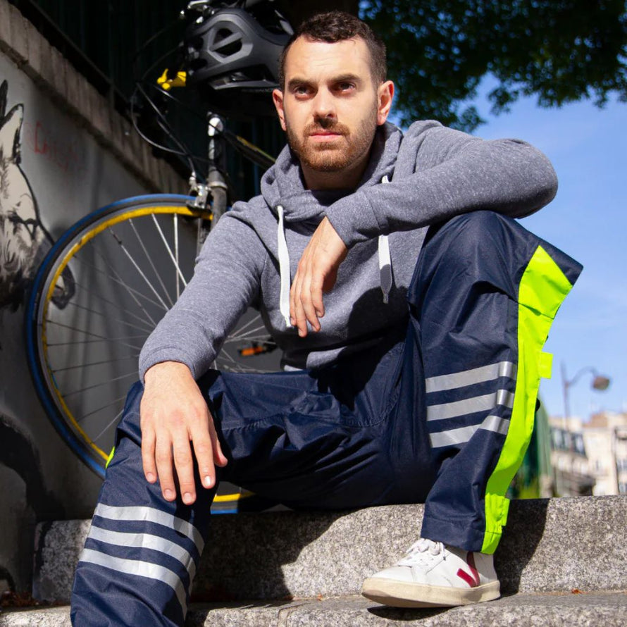 cycliste portant un pantalon de pluie vélo urban circus bleu en situation urbaine