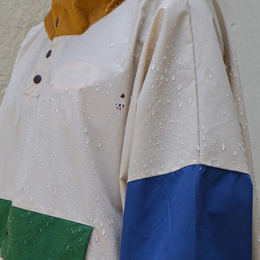 Poncho de pluie court Poule Party Old School beige avec manches bleues et capuche ocre imperméable