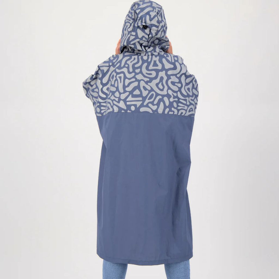 Femme de dos portant un poncho de pluie réfléchissant avec capuche pour vélo Romea Urban Circus bleu