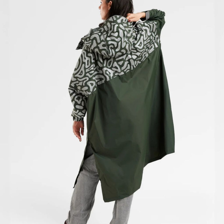 Femme de dos portant un poncho de pluie réfléchissant avec capuche pour vélo Romea Urban Circus kaki 