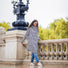 Femme souriante en poncho de pluie vélo recyclé Le Temps des Grenouilles motif pied-de-poule en extérieur urbain