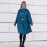 Femme souriante en poncho de pluie vélo recyclé Le Temps des Grenouilles motif pied-de-poule bleu en extérieur