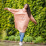 Femme joyeuse en poncho de pluie vélo recyclé Le Temps des Grenouilles couleur rose poudré en extérieur