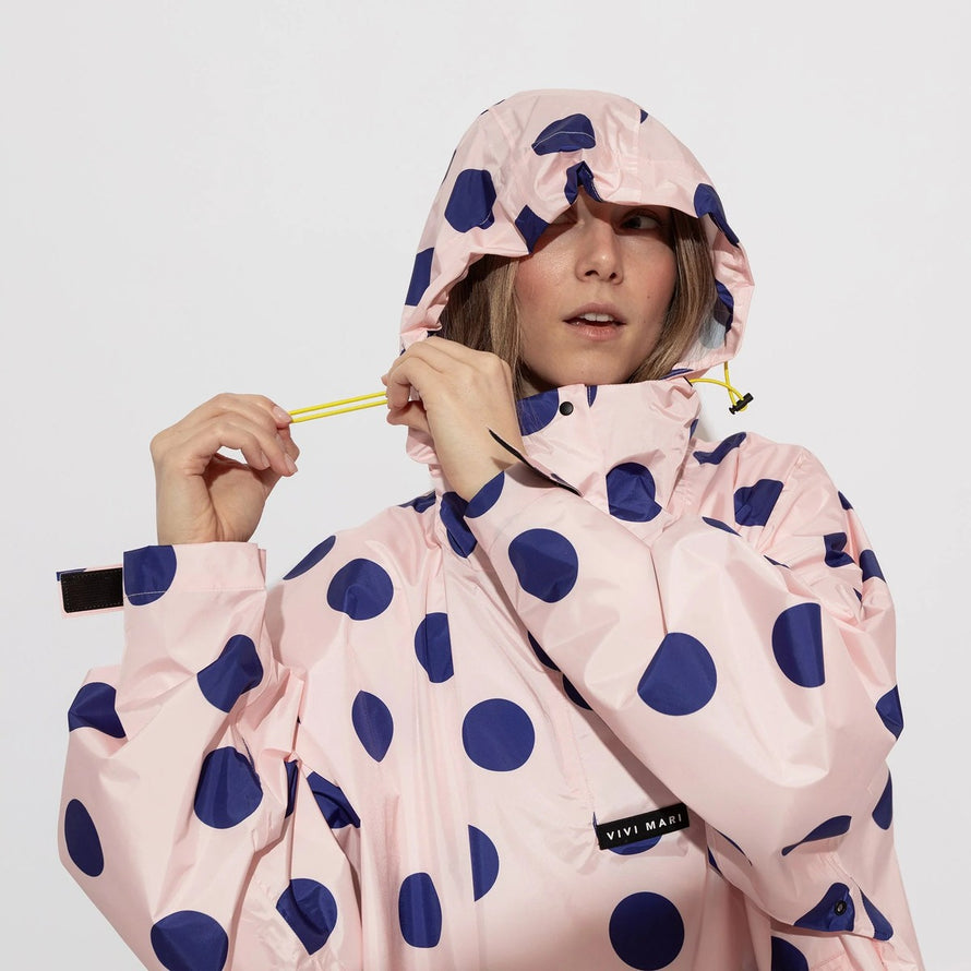 Poncho de pluie vélo Vivi Mari imperméable à pois bleus sur fond rose avec capuche ajustable pour cyclistes urbains