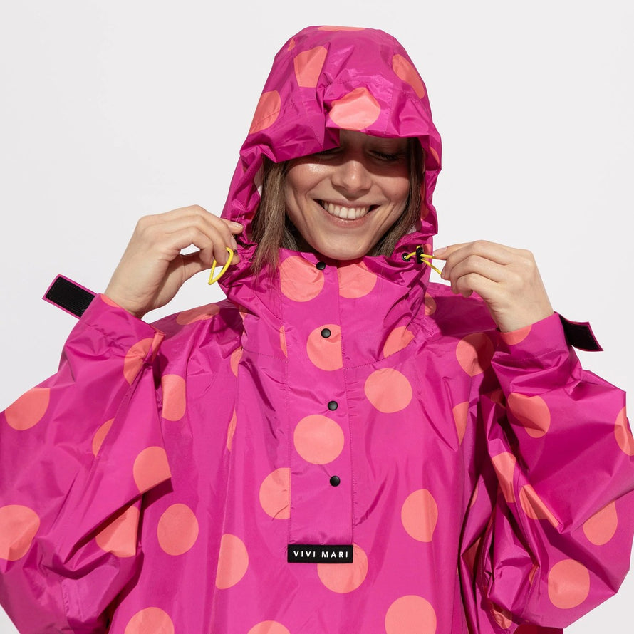 Poncho de pluie vélo Vivi Mari imperméable à gros pois rose et orange, idéal pour cyclistes urbains modernes
