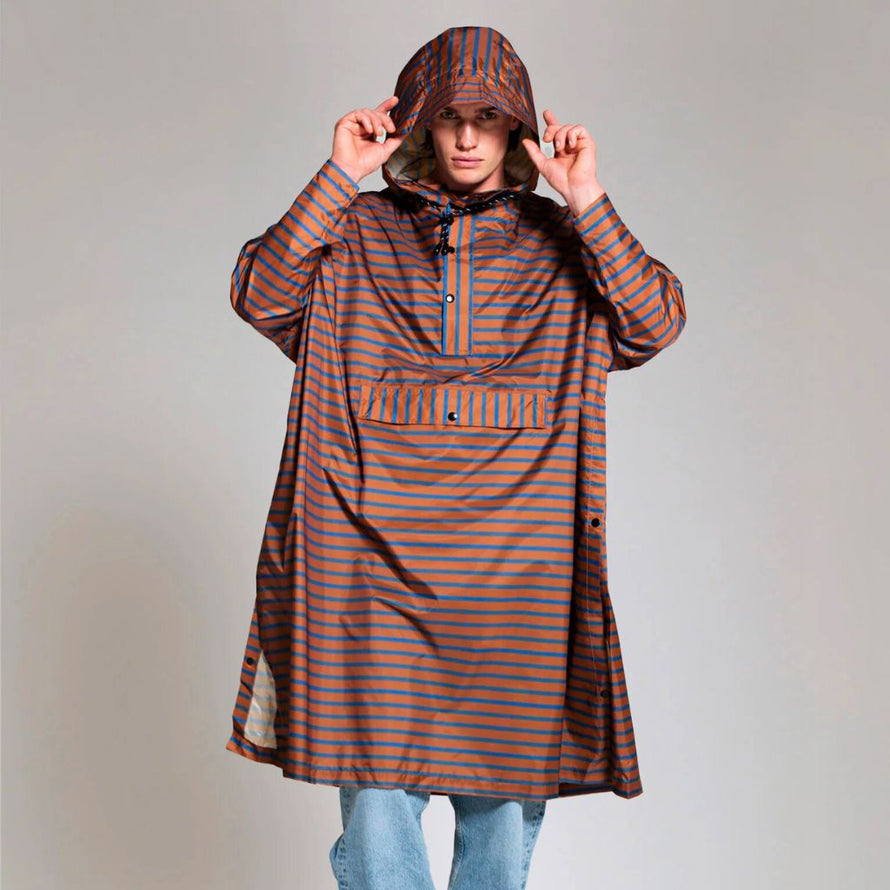 Poncho de pluie Rainkiss Breton Blue, motif rayé bleu et cuivre inspiré du style marin, pour pédaler avec élégance sous la pluie.