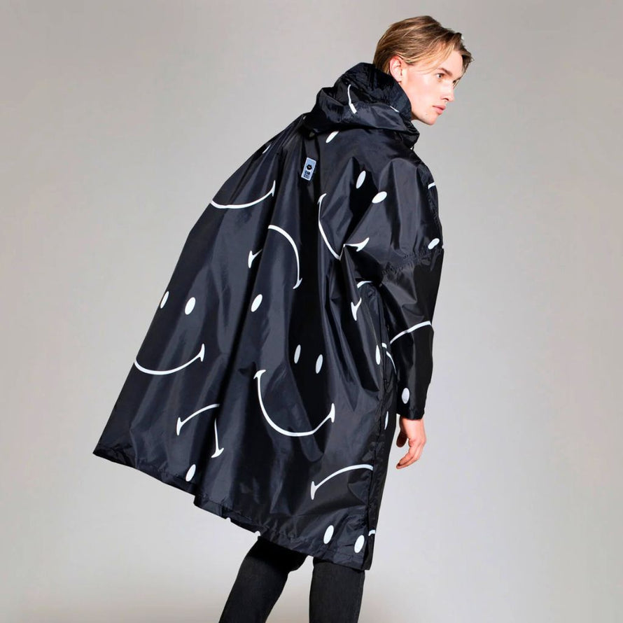 poncho Rainkiss Half Moon Smiley, coupe fluide et design monochrome inspiré du mouvement et de la bonne humeur.