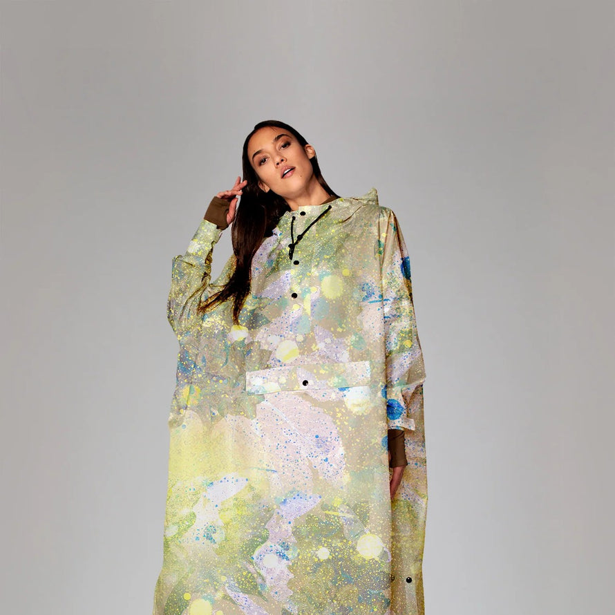 Poncho de pluie vélo recyclé Rainkiss avec motif abstrait coloré, imperméable et écologique pour cyclistes urbains.