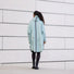 Femme vue de dos portant poncho de pluie vélo recyclé Le Temps des Grenouilles bleu clair urbain