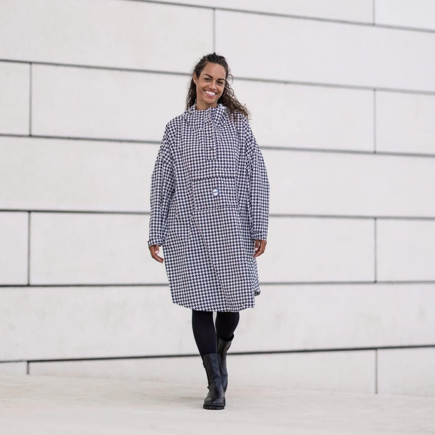 Femme souriante en poncho de pluie vélo recyclé Le Temps des Grenouilles motif pied de poule en marche